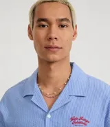 Kit de dos collares plateados de la marca VIKO. El conjunto incluye un collar de cadena con eslabones circulares y un segundo collar de cadena fina con perlas blancas distribuidas de forma espaciada. Ambas piezas cuentan con cierre de mosquetón y cadena de alargue para ajustar el largo.