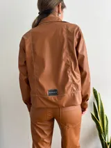 Campera de cuero sintético color marrón con cierre frontal y corte recto.