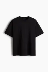 Remera negra de punto pesado con cuello redondo ribeteado, hombros caídos y bajo recto. Corte holgado confeccionada con tejido funcional COOLMAX®, una fibra de poliéster de secado rápido que elimina la humedad y regula la temperatura corporal.