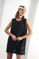 Vestido negro de textura liviana con detalles calados, corte amplio y bordes contrastantes.