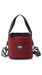 Matera color bordó con diseño acolchado, asa corta negra, correa larga regulable negra con estampado de rayas diagonales blancas y negras.