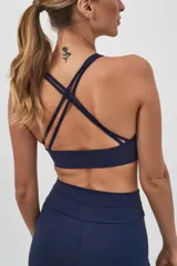 Top deportivo color verde militar con espalda cruzada en cuatro tiras y almohadillas removibles.