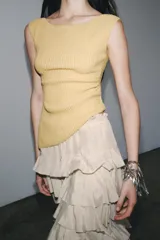 Musculosa color amarillo mostaza de tejido de punto acanalado, con cuello barco, sin mangas y detalle drapeado lateral.