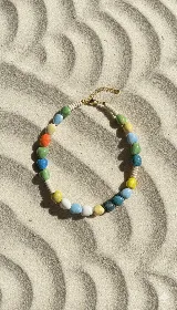 Collar corto con cuentas de cerámica de colores pastel, discos de piedra fósil color hueso y cierre de acero dorado con cadena de alargue.