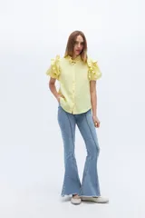 Camisa amarilla de lino con cuello mao y mangas cortas abullonadas con volados.