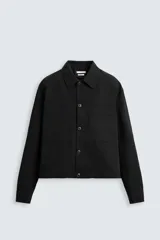 Sobrecamisa negra relaxed fit confeccionada en tejido con algodón, lino y lyocell. Cuello solapa y manga larga acabada en puño con botón. Bolsillos plastrón con solapa en pecho y laterales en cadera. Cierre frontal de botonadura.