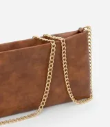 Billetera rectangular color celeste, confeccionada en cuero sintético, con cierre de cremallera y correa de cadena plateada.
