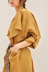 Saco color mostaza confeccionado en lino, de corte amplio y mangas largas. Incluye lazo estampado animal print.