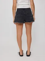 Short de jean negro con roturas y terminaciones desflecadas.