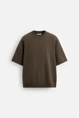 Sudadera negra de corte relaxed fit, confeccionada en tejido interlock de algodón con elasticidad. Tiene cuello redondo, manga corta y bajo acabado en rib.