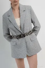 Cinturón de cuero color marrón claro con hebilla metálica plateada y apliques de tachas redondas y cuadradas.