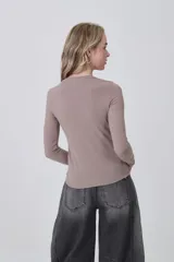 Remera de manga larga ajustada al cuerpo, color negro, con cuello redondo a la base y tejido acanalado.