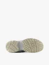 Zapatillas New Balance modelo 725, color blanco con detalles plateados y logo "N" en negro. Diseño inspirado en el estilo de carrera de los años 2000, con malla transpirable, entresuela con amortiguación y suela con agarre.