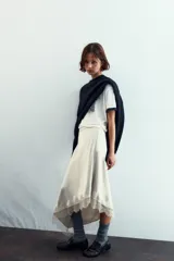 Falda color crema de satén con corte al bies y terminación asimétrica con encaje.