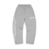 Pantalón de jogging gris con cintura elástica y cordón ajustable. Estampado lateral con el nombre de la marca en color blanco y logo en la pierna derecha.