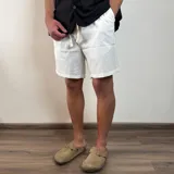 Bermuda negra de lino con corte arriba de la rodilla y cordón ajustable en la cintura.