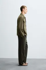 Sobrecamisa color beige de tejido efecto ante, corte regular fit, con cuello solapa, manga larga con puños abotonados, bolsillos de parche con solapa en el pecho y bolsillos de ojal en la cadera.