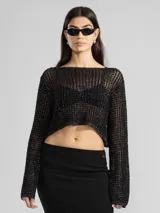 Sweater corto de punto calado color negro con lurex plateado, escote amplio y mangas largas.