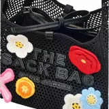 Bolso negro tejido a crochet con diseño de flores de colores y logo de la marca.