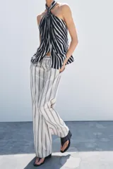 Pantalón palazzo de algodón color crudo con rayas verticales azules, tiro medio, cintura ajustable con cordones, bolsillos laterales ocultos y pierna recta.