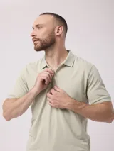 Remera tipo polo color beige, de manga corta y corte clásico, con cierre parcial frontal con cremallera.