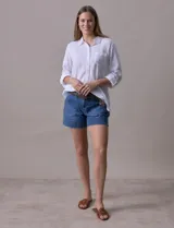Camisa blanca de lino, marca Dash, con cuello con solapa, abertura central con botones, bolsillo aplicado en el pecho y mangas largas regulables con presilla y botón.