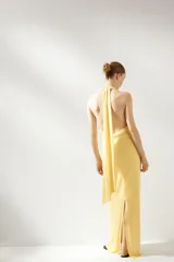 Vestido largo amarillo con escote halter y espalda descubierta, atado al cuello.