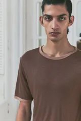 Remera marrón de corte recto con cuello redondo y ribete en color beige en cuello y mangas.