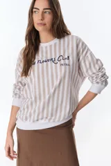 Buzo blanco con rayas verticales color beige, cuello redondo y puños blancos. Estampado en el pecho con la frase "The Flowers Club Petra" en azul marino.