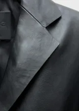 Americana de cuero ovino color negro, con cuello de pico con solapa, diseño crop y entallado, cierre delantero con botones y dos bolsillos de solapa.