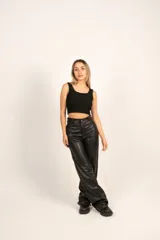 Pantalón de ecocuero negro con pinzas traseras y pasa cinto, de corte amplio y diseño contemporáneo.