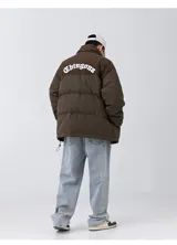 Campera puffer marrón con parte superior de pana y bordado blanco en la espalda con la palabra "Chingona". Tiene tiras regulables en la cintura.