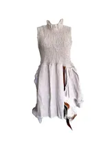 Vestido corto color beige, confeccionado en lino con tiras de cuero vacuno. Presenta elástico en la parte superior y falda irregular en lino y cuero.