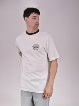 Remera color crudo con cuello redondo marrón y estampado en el pecho con texto y logo de campeonato de Los Ángeles. Corte recto y mangas cortas.