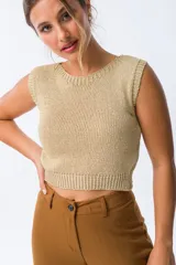 Musculosa color dorado de tejido de punto calado, con cuello redondo y sisas amplias.