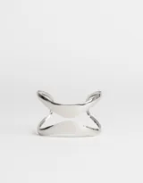 Brazalete rígido de metal plateado con diseño geométrico abierto.