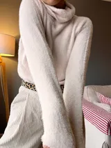 Sweater de cuello alto color beige, de tejido suave y mangas largas.