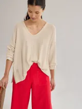 Sweater color crema, de tejido liviano y calce holgado.