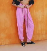 Pantalón de vestir rosado, de corte ancho, con bolsillos laterales y cintura alta con lazos.