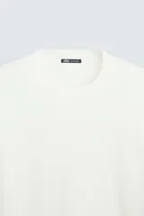 Jersey color topo de corte amplio, tejido en hilatura con mezcla de viscosa. Tiene cuello redondo, manga larga y terminaciones en rib.
