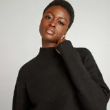 Sweater negro de punto suave con cuello alto y corte holgado.