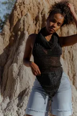 Top tejido al crochet color negro, con capucha integrada y diseño artesanal.