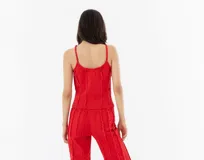 Top rojo de gabardina con breteles finos y cierre metálico frontal.