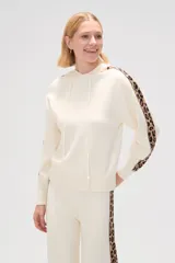 Sweater color crema con capucha y cordones, de tejido de punto, con mangas largas y detalle de franja con estampado animal en mangas y laterales.
