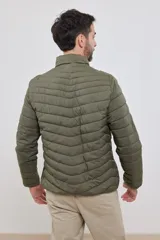 Campera capitoneada liviana color azul marino, con cuello alto y dos bolsillos exteriores con cierre. Interior del cuello a contratono.