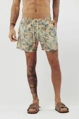 Short de baño con estampado de hojas de palmera en tonos beige, verde y naranja.