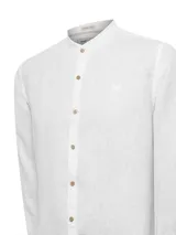 Camisa blanca de lino orgánico con cuello mao, manga larga y cierre frontal con botones de madera.