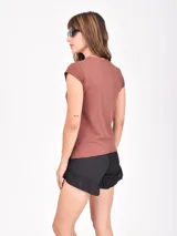 Remera de manga corta color lila claro, con cuello redondo y bordes deshilachados. Presenta un estampado central de dos leopardos dentro de un marco cuadrado, con los patrones de sus manchas en forma de corazones.