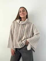 Sweater color crema de mohair con cuello alto y mangas anchas. Tejido con calados verticales y bordado a mano con lana merino.