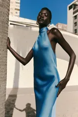 Vestido largo de satén color celeste, con cuello halter y espalda descubierta. Cierre trasero con cremallera oculta.